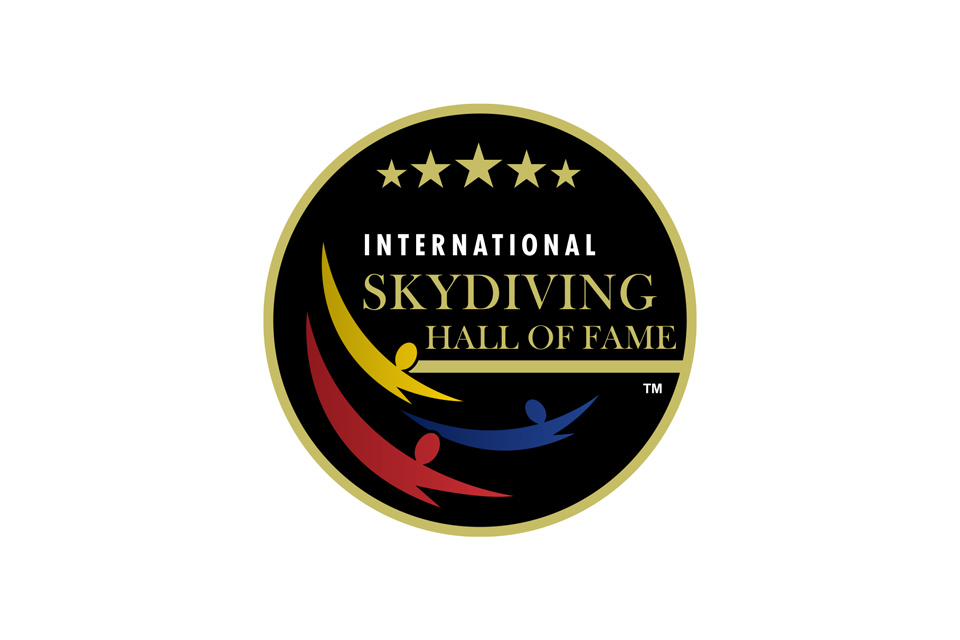 Logo of the International Skydiving Hall of Fame with three abstract figures in red, blue, and yellow on a black background. The circular design includes five gold stars above the text.