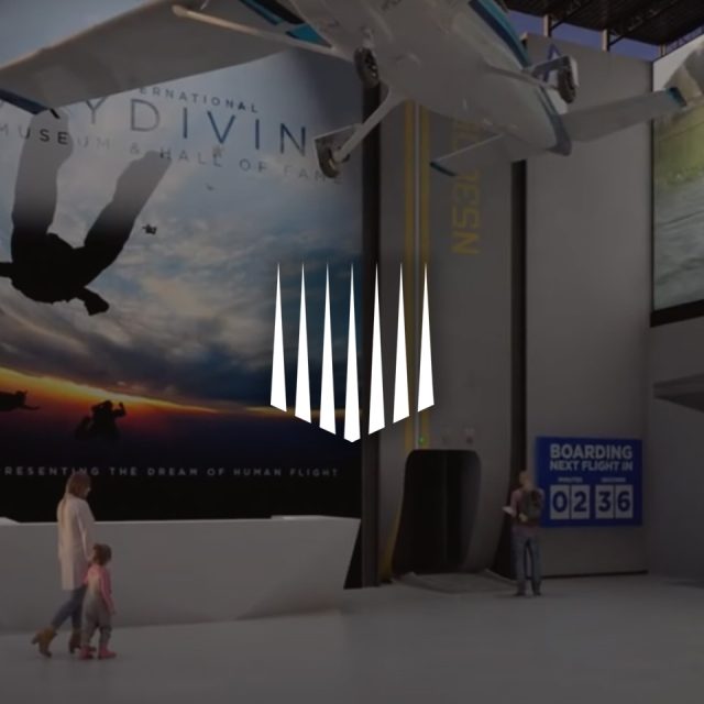 A man and child walk past a skydiving advertisement inside a building, with boarding sign "02:36" visible. An airplane model is suspended overhead.