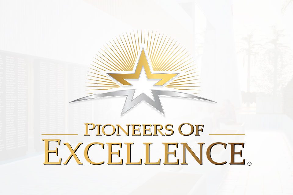 Logo featuring a gold and silver star with rays extending outward, above the text "Pioneers of Excellence" in gold and silver. The background is a blurred outdoor setting with trees and a building.